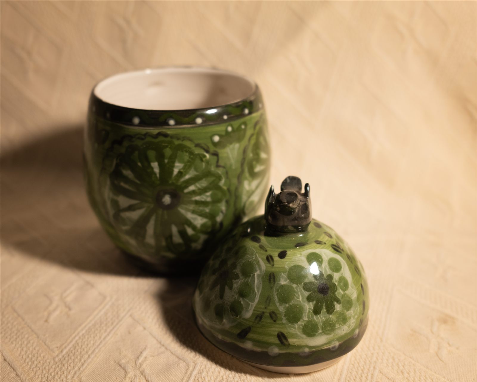 Green floral canister with bird finial, open